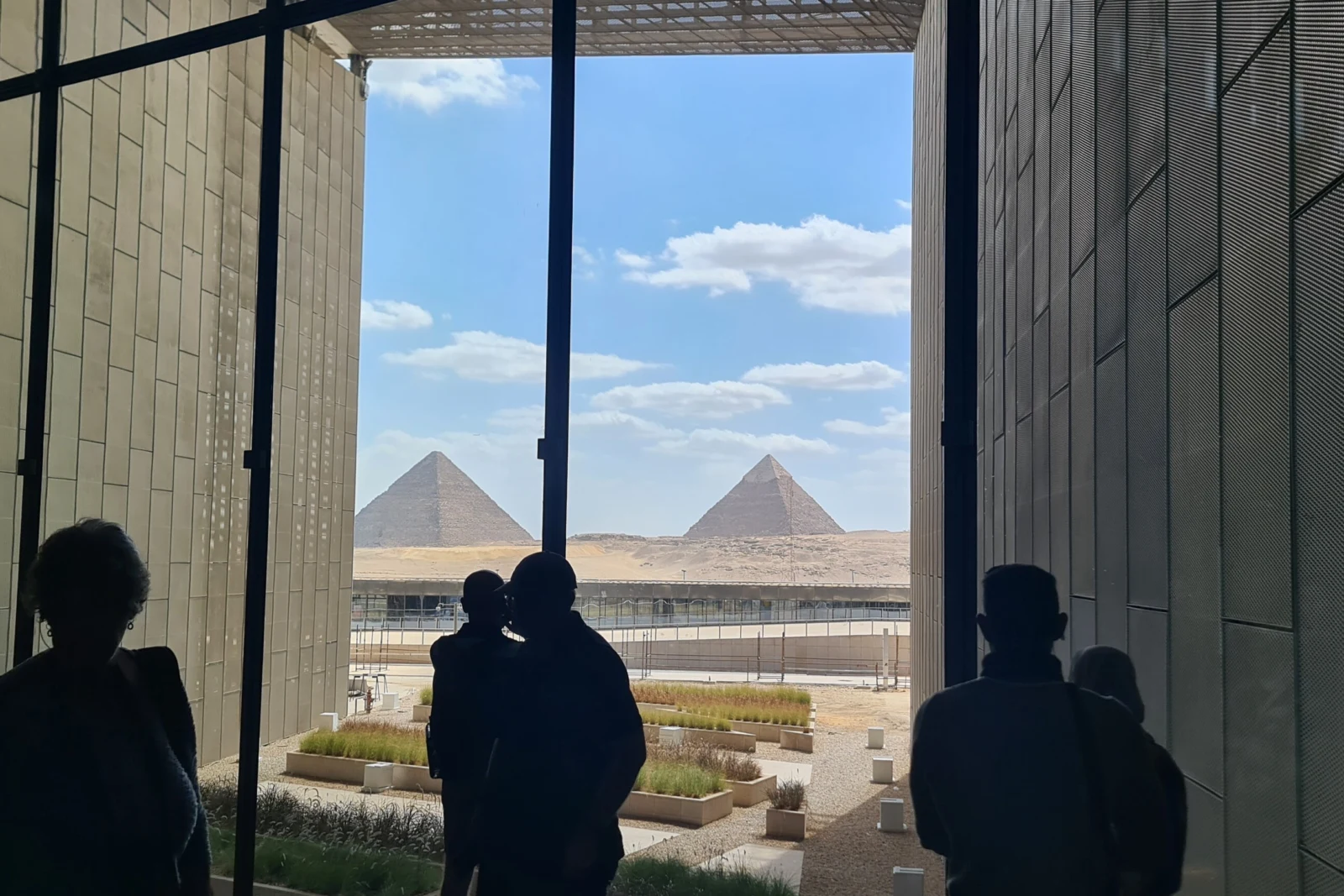 An ancient Egyptian statue displayed in a modern museum hall
